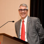 Vice Chancellor smiling to the camera on stage