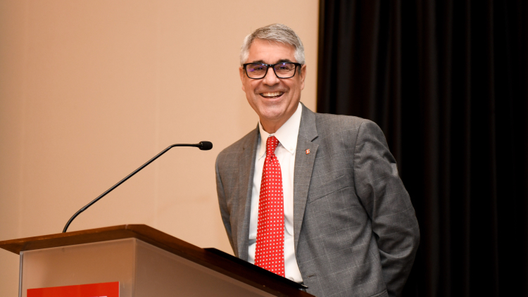 Vice Chancellor smiling to the camera on stage