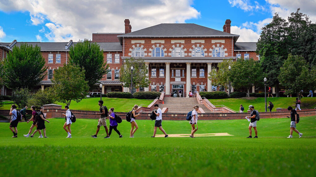 Students make their way to class early in the 2022 fall semester across the Court of North Carolina, with the 1911 Building as a backdrop.