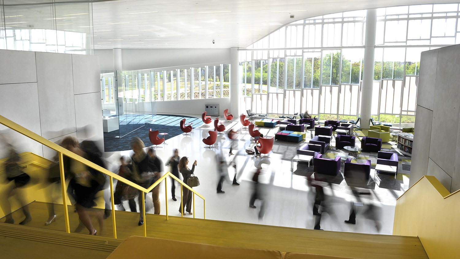 Wide shot of the interior of James B. Hunt Jr Library with blurry people moving around the space.