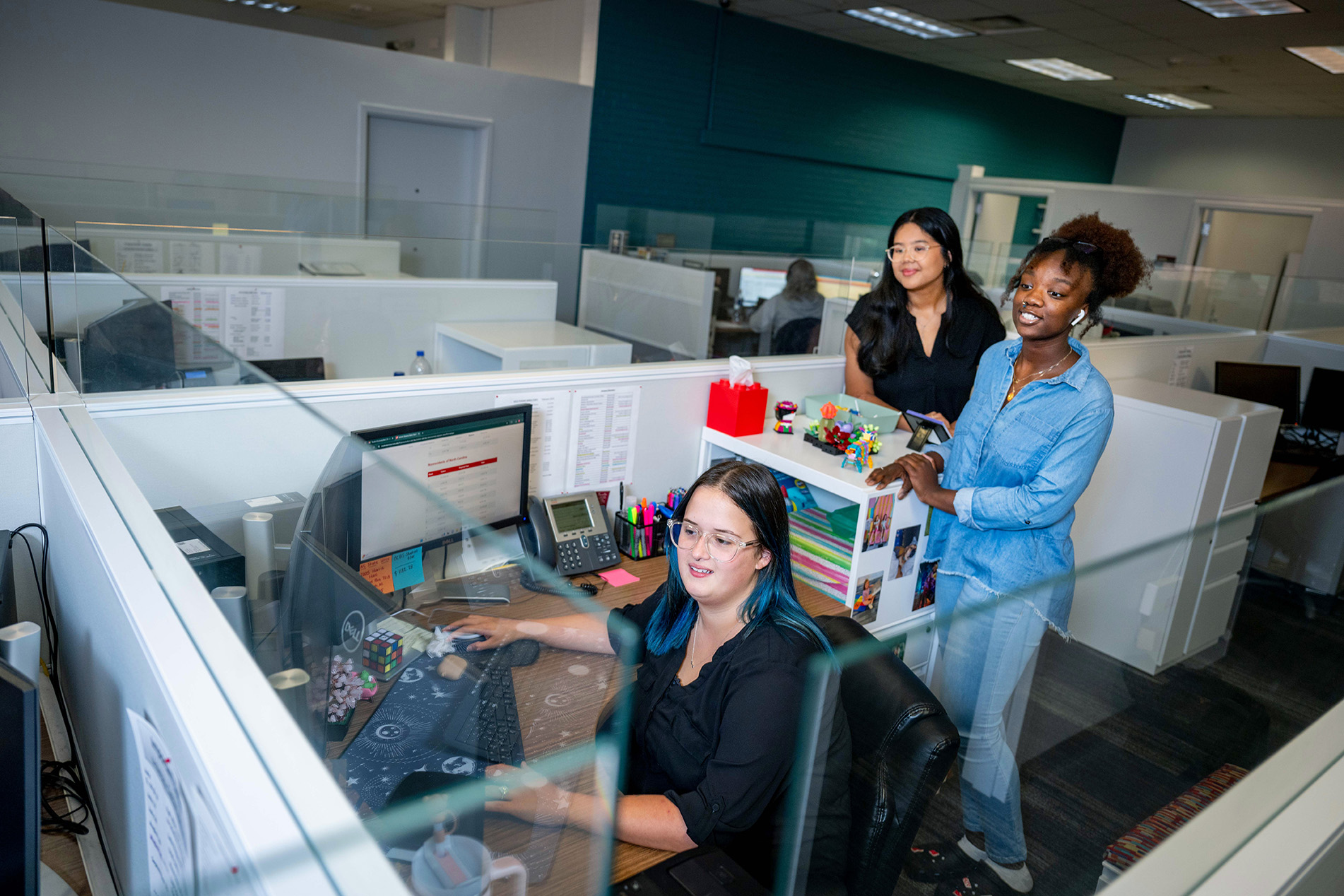 Cashier's Office employee helps two students with questions.